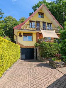 une maison jaune avec une allée devant elle dans l'établissement Duży Domek Nad Jeziorem - Kretowiny 64, à Kretowiny