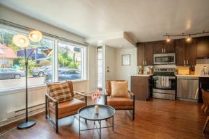 a living room with a table and chairs and a kitchen at Seaside Serenity 1 BR Apt with balcony near Alki in Seattle