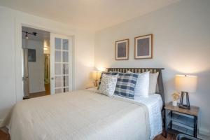 Schlafzimmer mit einem Bett mit blauen und weißen Kissen in der Unterkunft Seaside Serenity 1 BR Apt with balcony near Alki in Seattle
