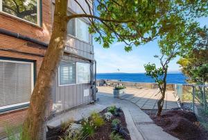 a house with a door with the ocean in the background at Seaside Serenity 1 BR Apt with balcony near Alki in Seattle