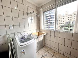 Un baño pequeño con lavabo y ventana. en Jurere, en Meia Praia 46 fotos más