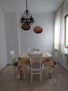 une salle à manger avec une table, des chaises et un lustre dans l'établissement Didi House, à Sandanski