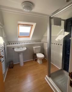 une salle de bain avec toilettes, lavabo et douche dans l'établissement Buttercup Cottage, à Killean
