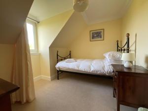 a bedroom with a bed and a window at Buttercup Cottage in Killean