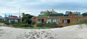 a house sitting on top of a sandy beach at 14 Penguin Place, Melkbosstrand in Melkbosstrand