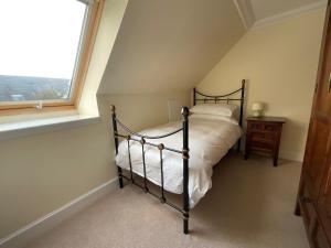une chambre avec un lit et une fenêtre dans l'établissement Buttercup Cottage, à Killean