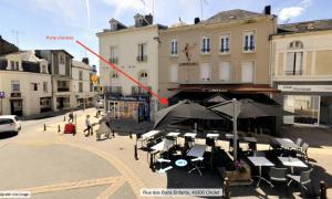 una freccia rossa indica un edificio con tavoli e ombrelloni di Myaka©Appartement Fontana a Cholet