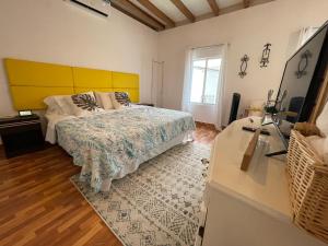1 dormitorio con 1 cama con cabecero amarillo en Suite Tierra - The Garden House, en Pedro Vicente Maldonado