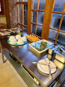 a table with plates and utensils on it in a kitchen at Hotel Corvatsch in San Pedro de Atacama