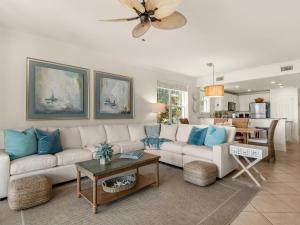 a living room with a white couch and blue pillows at San Remo Condominium 209 by Newman-Dailey in Santa Rosa Beach