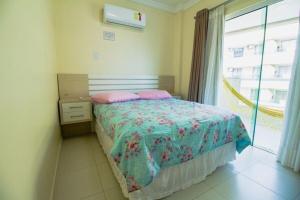 a bedroom with a bed and a window at 201- Apartamento Bombas com vista lateral do mar in Bombas
