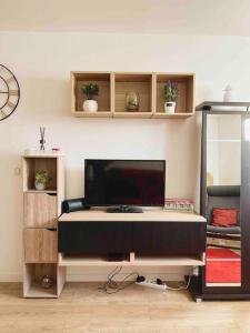 a living room with a flat screen tv on a wall at Appartement Ensoleillé à 15 minutes de Paris in Vitry-sur-Seine