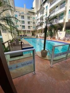 a swimming pool with a palm tree in a building at Apartamento Summer Beach Bombas in Bombas