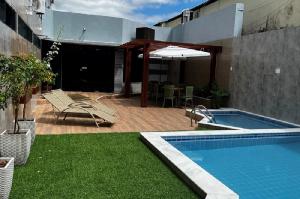 a patio with a swimming pool next to a building at Hotel Sabino Palace in Mossoró