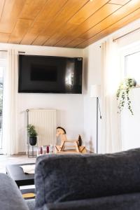 sala de estar con sofá y TV en la pared en Auszeit Altenhorst, en Schalksmühle