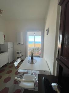 a white table and chairs in a room with a window at Casetta 1870 in Ortona +17 photos