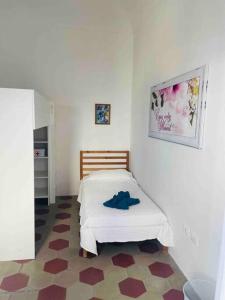 a bedroom with a white bed and a checkered floor at Casetta 1870 in Ortona
