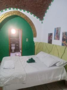 Cama en habitación con pared verde en Green Palace Garden, en Luxor