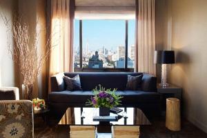 a living room with a blue couch and a window at Soho Grand Hotel in New York