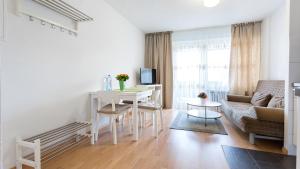 uma sala de estar branca com uma mesa e um sofá em Apartments an der Uniklinik em Freiburg im Breisgau
