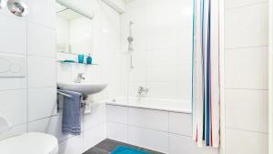 Un baño blanco con lavabo e inodoro. en Apartments an der Uniklinik, en Freiburg im Breisgau 17 fotos más