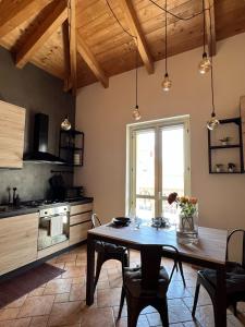 eine Küche mit einem Holztisch und einem Esszimmer in der Unterkunft S a p p h i r e H o M e - Rivarolo DesignApartment in Rivarolo Canavese