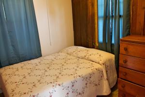 a small bedroom with a bed and a dresser at Pine Haven Beach Resort in Tawas City