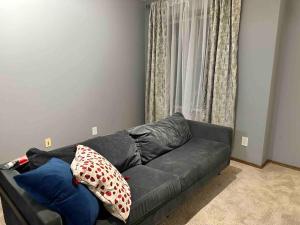 a gray couch in a living room with a window at Spacious, 2-story Family-Friendly home in Calgary