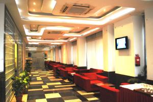 a waiting room with red chairs and a tv at The Park Classic in Jaipur