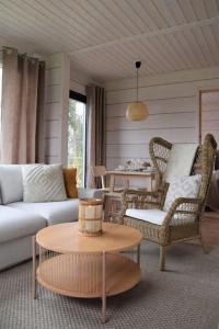 een woonkamer met een bank, stoelen en een tafel bij Villa Riverside in Rovaniemi