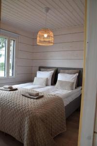 een slaapkamer met een groot bed en een kroonluchter bij Villa Riverside in Rovaniemi