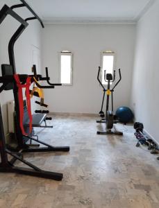 a gym with several tread machines in a room at JasminVilla in Sousse
