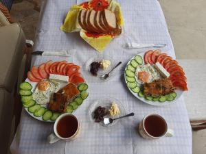 a table with two plates of food and two cups of coffee at Guesthouse Shtino in Gjirokastër