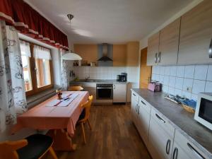 een keuken met een houten tafel en een keuken met een tafel bij Panoramic view holiday home, Neureichenau in Neureichenau