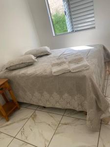 a bedroom with a bed with two towels on it at Apart. Bela Vista in Pôrto Ferreira