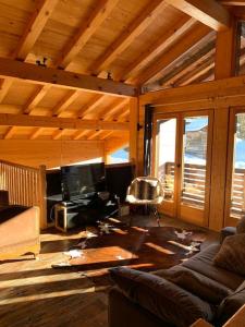 sala de estar con sofá y TV en Superbe CHALET (14 personnes) & SAUNA au pied du Mont Blanc en Les Contamines-Montjoie