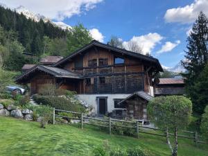 a large wooden house in the middle of a field at Superbe CHALET (14 personnes) & SAUNA au pied du Mont Blanc in Les Contamines-Montjoie