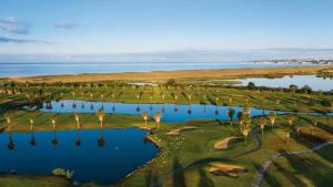 an aerial view of a golf course with palm trees and water at Herdade dos Salgados, Beach Villa, 3 Suites in Guia