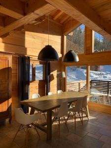 comedor con mesa de madera y sillas en Superbe CHALET (14 personnes) & SAUNA au pied du Mont Blanc en Les Contamines-Montjoie