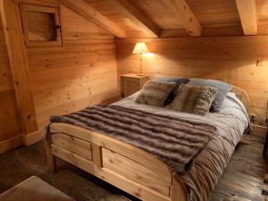 a bedroom with a bed in a log cabin at Superbe CHALET (14 personnes) & SAUNA au pied du Mont Blanc in Les Contamines-Montjoie