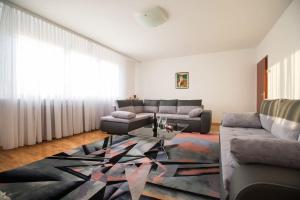 Apartment Check In Zagreb Maksimir-free parking في زغرب: غرفة معيشة مع أريكة وطاولة
