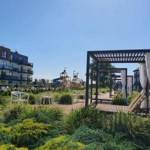 a garden with tables and chairs in a park at Bel Mare Resort ekskluzywny apartament dla wymagających klientów in Międzyzdroje