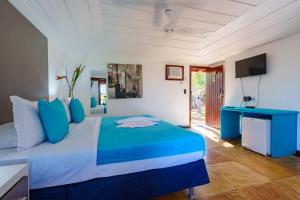 a bedroom with a blue and white bed and a television at Royal Turquesa Boutique Hotel in Búzios +90 photos