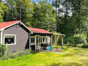 une petite cabine avec un toit rouge dans une cour dans l'établissement 4 person holiday home in H STVEDA, à Lur