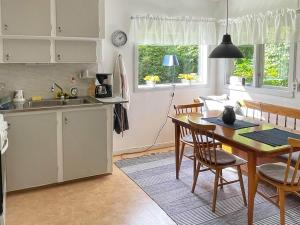 a kitchen and dining room with a table and chairs at 4 person holiday home in H STVEDA in Lur