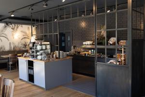 a restaurant with a counter and a kitchen with a counter at das seidl - Hotel & Tagung - München West in Puchheim