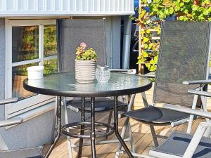 una mesa y sillas en un patio con una maceta en 5 person holiday home in LYSEKIL en Lysekil