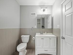 Baño blanco con aseo y lavamanos en Oakland/University @G Modern and Bright Private Bedroom with Shared Bathroom en Pittsburgh