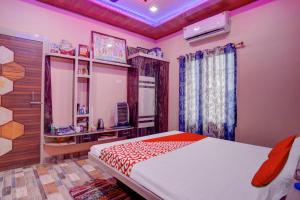 - une chambre avec un grand lit et une fenêtre dans l'établissement OYO Flagship 81389 Hotel Siddhi Vinayak, à Motīhāri