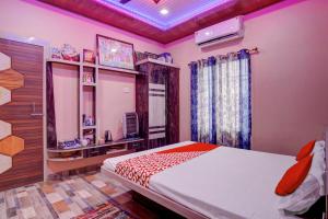 Motīhāri的住宿－OYO Flagship 81389 Hotel Siddhi Vinayak，一间卧室配有一张床和一台电视。